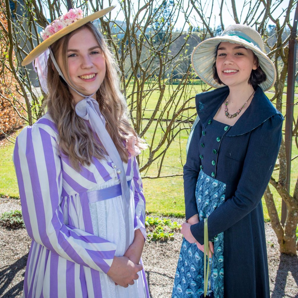 Two young women wearing period costume from the Regency era